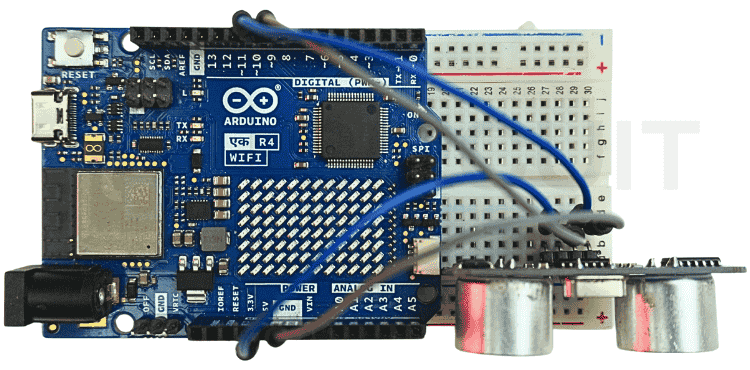 Assembled Arduino UNO R4 WiFi and HC-SR04 ultrasonic sensor hardware prototype for the Arduino WhatsApp notification system on a breadboard